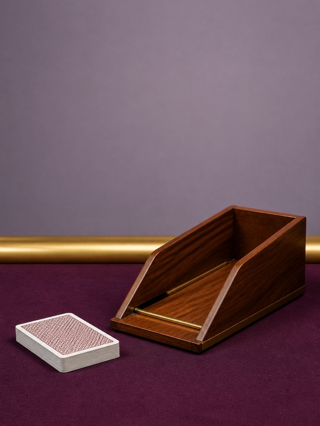 Wooden baccarat shoe and unused cards on plum felt