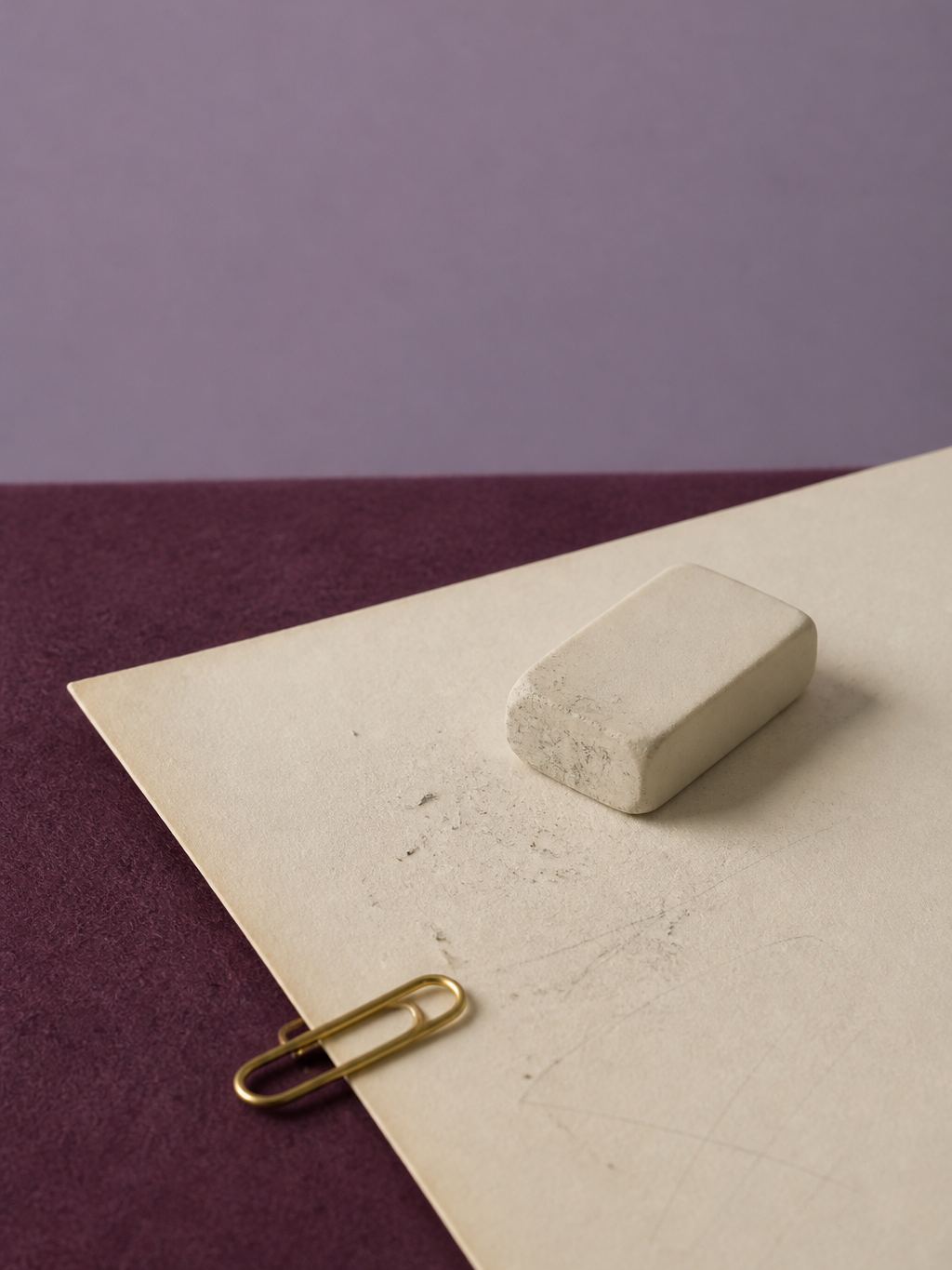 Eraser and a marked cream page on plum felt