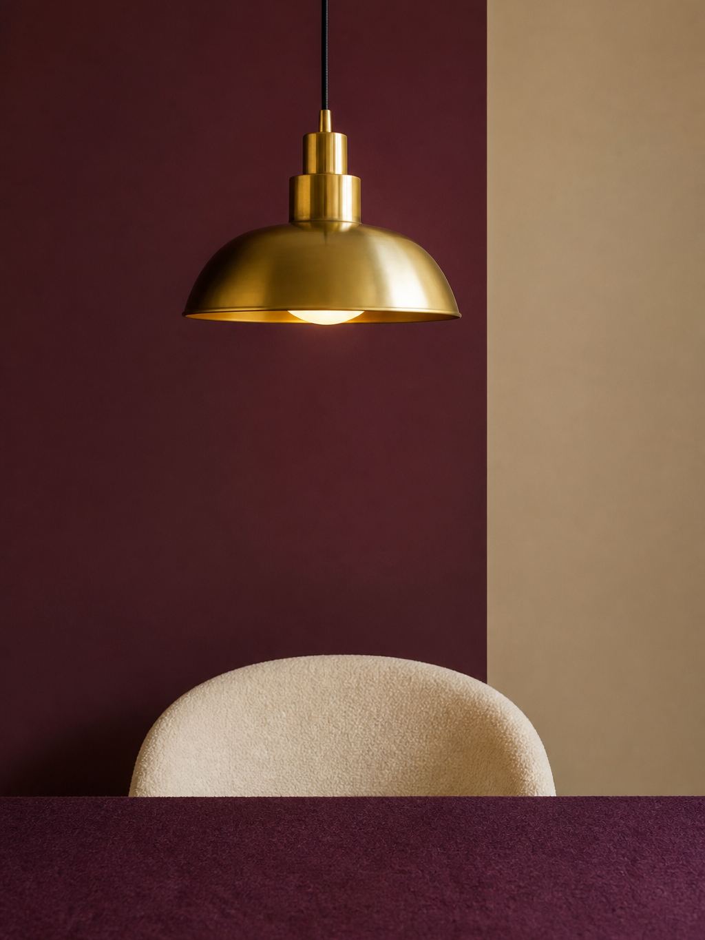 Brass lamp over an empty chair beside a felt table edge