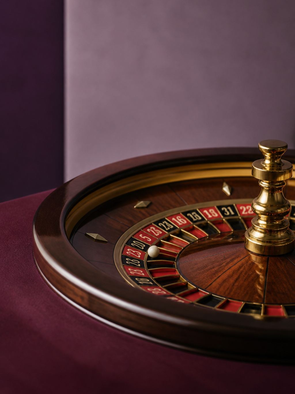 Close-up of a roulette wheel on plum felt with a brass ball track
