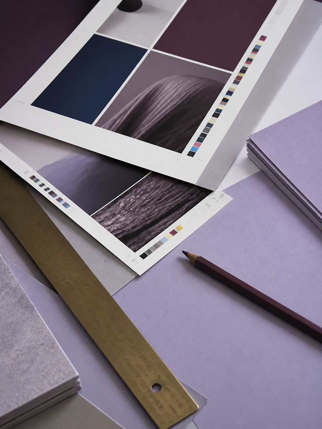Printed proof sheets with a brass ruler and plum pencil